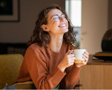 Een vrouw geniet thuis van een warme drank
